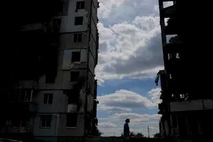 Una mujer pasa ante un edificio destruido durante ataques en Borodyanka, a las afueras de Kiev, Ucrania, el sábado 4 de junio de 2022. (AP foto/Natacha Pisarenko)