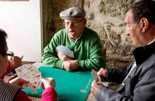 Parroquianos de Muros, en las Rías Baixas, juegan a las cartas.