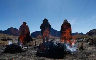 ARCHIVO - La gente quema ofrendas en honor a la Pachamama en La Cumbre, una montaña considerada sagrada en las afueras de La Paz, Bolivia