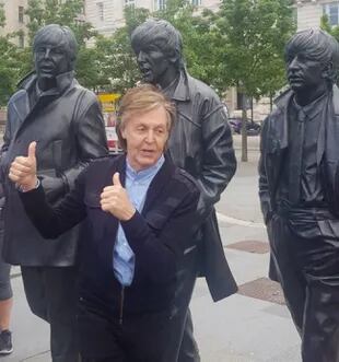 Paul, frente a la escultura de los cinco de Liverpool