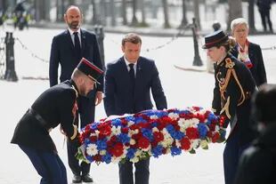 El presidente francés, Emmanuel Macron, coloca una corona de flores durante una ceremonia para conmemorar el final de la Segunda Guerra Mundial en el Arco del Triunfo en París el 8 de mayo de 2020