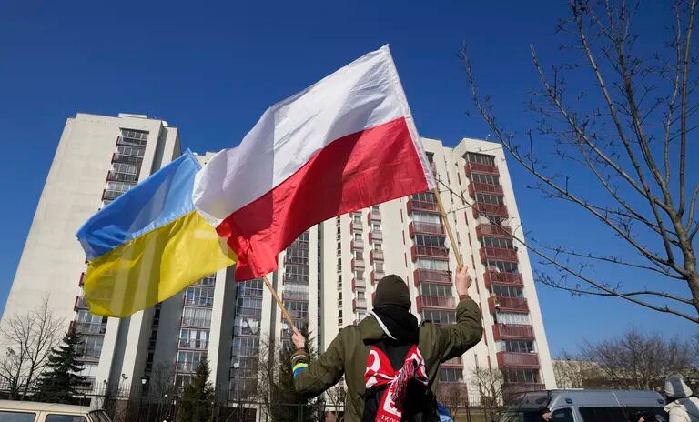 ARCHIVO _ Un hombre ondea banderas de Polonia y Ucrania durante una manifestación delante de un edificio que alberga a diplomáticos rusos en Varsovia el 13 de marzo del 2022. 