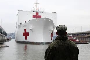 La llegada del USNS Comfort al puerto de Manhattan bajo la atenta mirada de un miembro de la Armada