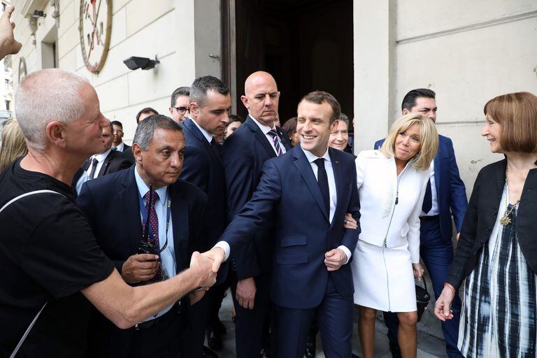 Frances President Emmanuel Macron (C) shakes hands with a man next to Frances First Lady Brigitte Macron (2-R) during their visit to the Metropolitan Cathedral in Buenos Aires on November 29, 2018. - Macron arrived on the eve for a two-day G20 summit beginning on November 30 likely to be dominated b