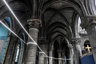 Un cable de luz se extiende entre columnas durante el trabajo preliminar en la Catedral de Notre-Dame