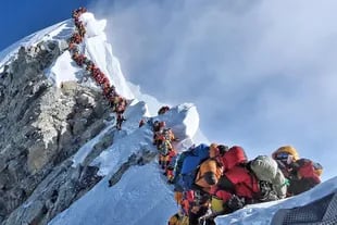 Cientos de personas tratan de subir a la cima del Everest cada año -la foto es de una congestión de montañistas que hubo en el monte en 2019- y algunos de ellos dejan la vida en el intento