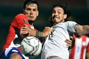 El capitán paraguayo Gustavo Gómez, que fue expulsado por el árbitro argentino Darío Herrera, forcejea con Edinson Cavani, el delantero uruguayo que saltó desde el banco de los suplentes en el segundo tiempo