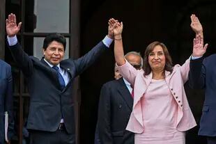 En esta foto de archivo tomada el 21 de noviembre de 2022 el presidente peruano Pedro Castillo saluda a los medios junto a la vicepresidenta Dina Boluarte tras una reunión con una misión de la OEA en el Palacio de Gobierno en Lima.