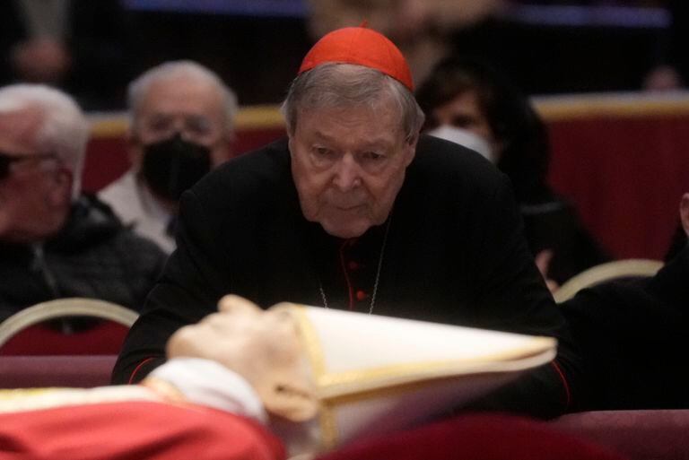 FILE - Australian Cardinal George Pell stands next to the body of late Pope Benedict XVI lying in state inside St. Peter's Basilica at The Vatican, Tuesday, Jan. 3, 2023. Pell, who was the most senior Catholic cleric to be convicted of child sex abuse before his convictions were later overturned, has died Tuesday, Jan. 10, 2023, in Rome at age 81. (AP Photo/Gregorio Borgia, File)