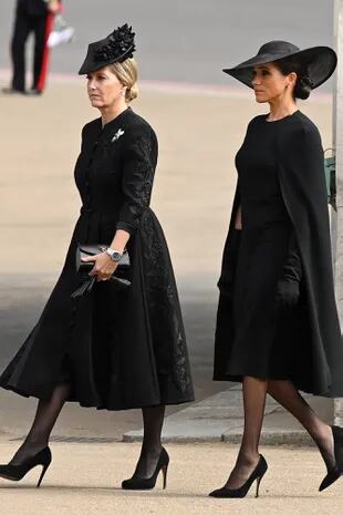 Sofía, la condesa de Wessex (con vestido de Suzannah London), junto a Meghan, duquesa de Sussex, con un diseño de mangas capa de Stella McCartney y guantes largos. Llevó pendientes de perlas y diamantes que la Reina le regaló durante su compromiso oficial en junio de 2018.