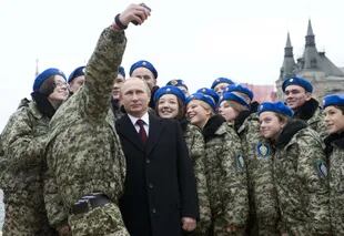 El presidente ruso Vladimir Putin posa para una selfie con jóvenes activistas en la Plaza Roja de Moscú