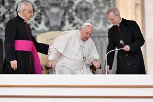 Der Papst wird während der öffentlichen Versammlung vom Leiter des Papsthauses, Monsignore Leonardo Sabienza, und dem argentinischen Priester, Monsignore Luis Maria Rodrigo Evert, unterstützt.  (Foto von Alberto PIZZOLI / AFP)