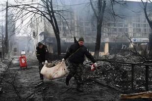 Agentes de policía retiran el cuerpo de un transeúnte asesinado en el ataque aéreo de ayer que golpeó la principal torre de televisión de Kiev, el 2 de marzo de 2022