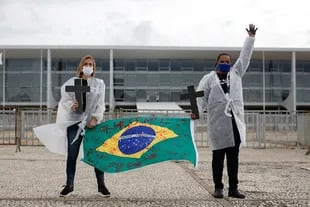 Enfermeras protestan contra el presidente brasileño Jair Bolsonaro y rinden homenaje a los trabajadores de la salud que murieron por complicaciones del nuevo coronavirus durante una manifestación frente al Palacio Planalto, en Brasilia, el 1 de mayo de 2021