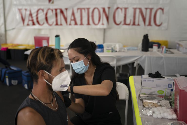 La enfermera Noleen Nobleza aplica la vacuna contra el COVID-19 a Julio Quiñones en Orange (California), el 28 de agosto del 2021. (AP Photo/Jae C. Hong, File)