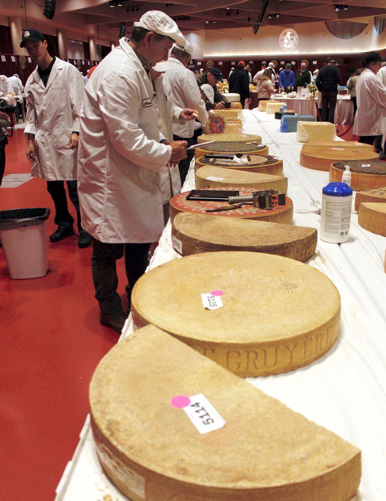 El juez Christophe Megevand inspecciona una rueda de queso Gruyere en el Concurso Mundial de Queso del Campeonato Mundial, el 3 de marzo de 2020, en el Centro de Convenciones Monona Terrace en Madison, Wisconsin.