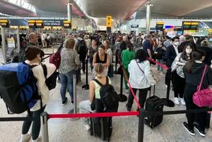 FILE - Travelers line up at London Heathrow Airport on June 22, 2022. (AP Photo/Frank Augstein, File)