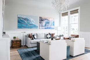 La tendencia en decoración copia el de las casas de los Hamptons, con grandes ventanas y estanterías empotradas pintadas de blanco, y los tapizados y cortinas en colores crema, azul y beige 