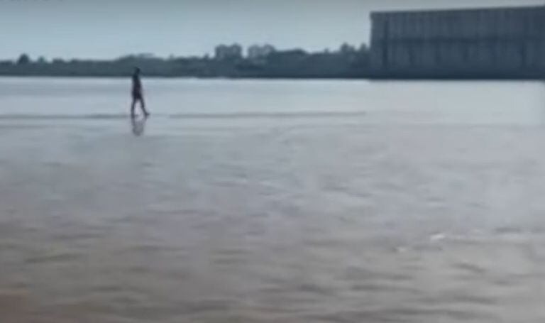 Un joven camina en el medio del río Paraná