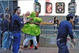 El personal de Apple Store saluda a los clientes que han estado esperando para comprar los nuevos iPhone