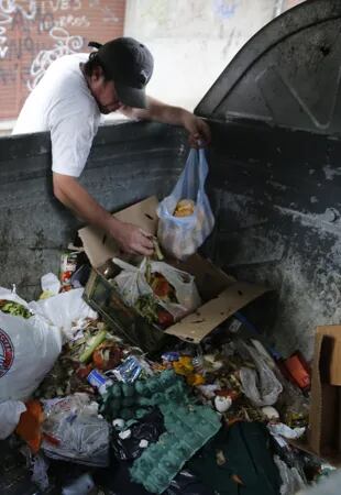 Una persona revuelve la basura en busca de comida, en el barrio de Palermo