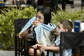 Un mujer y un niño miran atentos el partido de Argentina vs Polonia en el bar Vip de Rosario