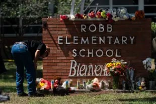 Un miembro de las fuerzas del orden enciende una vela frente a la escuela primaria Robb en Uvalde, Texas, el miércoles 25 de mayo de 2022.