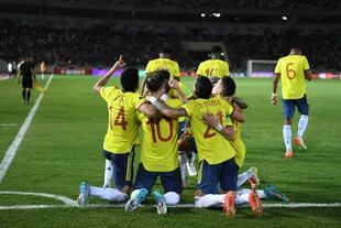 James Rodríguez se abraza con sus compañeros de equipo luego de anotar el primer tanto del partido, que mantiene a Colombia con vida.