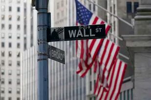 Un letrero de Wall Street frente a unas banderas estadounidenses afuera de la Bolsa de Valores de Nueva York, el viernes 14 de enero de 2022. (AP Foto/Mary Altaffer, Archivo)