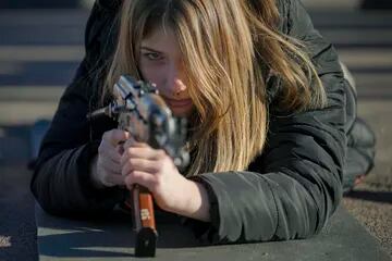 Una joven sostiene un arma durante un entrenamiento de combate básico para civiles, organizado por la Unidad de Fuerzas Especiales Azov, de la Guardia Nacional de Ucrania, en Mariupol, región de Donetsk, este de Ucrania, el domingo 13 de febrero de 2022