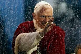 El papa Benedicto XVI saluda desde su móvil papal mientras llueve, después de la oración tradicional para celebrar la Inmaculada Concepción, en Roma, el 8 de diciembre de 2009.