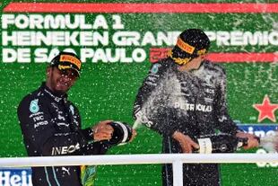 George Russell festeja en el podio junto a Lewis Hamilton y  luego de ganar el GP de Brasil, el único premio que ganó la Mercedes en la temporada 2022.