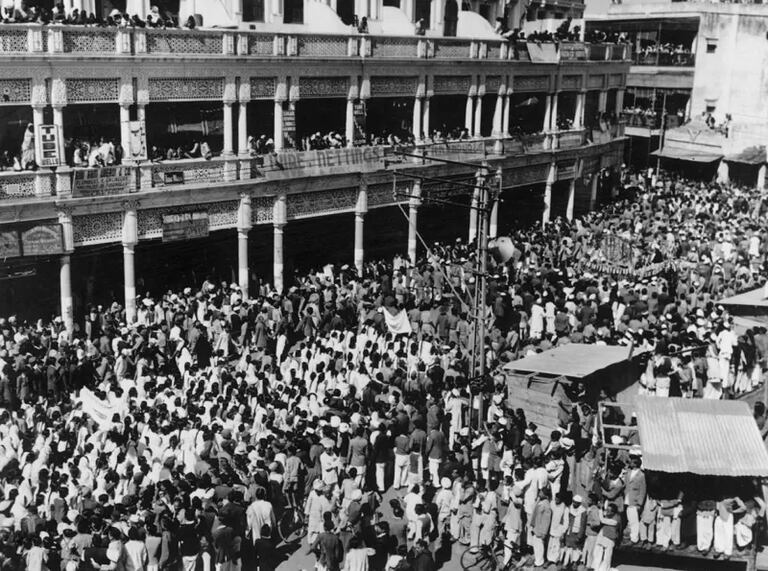 February 1948: Large crowds follow the body of assassinated Indian nationalist leader Mahatma Gandhi as it slowly passes along the funeral route to the immersion ceremony in New Delhi