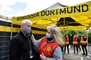 Dortmund: un miembro de un equipo de televisión está tomando la temperatura antes de entrar en el Signal-Iduna-Park antes del partido de fútbol de la Bundesliga alemana entre el Borussia Dortmund