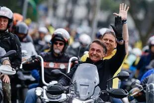El presidente de Brasil, Jair Bolsonaro, que se presenta a la reelección, encabeza una caravana de entusiastas de las motocicletas con el candidato a gobernador de Sao Paulo, Tarcisio de Freitas, montando en el asiento trasero, durante un acto de campaña en Sao Paulo, Brasil, el sábado 1 de octubre de 2022.
