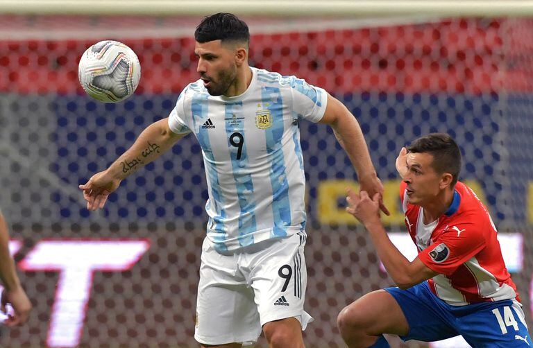 El argentino Sergio Agüero (izq.) Y el paraguayo Andrés Cubas compiten por el balón durante el partido de la fase de grupos del torneo de fútbol Conmebol Copa América 2021 en el estadio Mane Garrincha de Brasilia el 21 de junio de 2021.