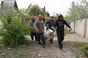Voluntarios exhuman cuerpos de civiles asesinados por ataques rusos en el poblado de Stepaky, cerca de Járkiv, Ucrania, el miércoles 11 de mayo de 2022. (AP Foto/Andrii Marienko)