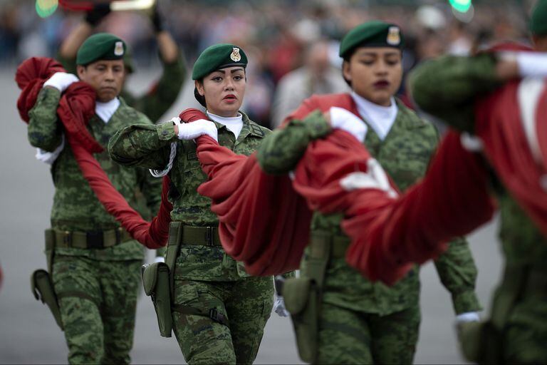 Las fuerzas Armadas femeninas sostienen una bandera en conmemoración al Día de la Mujer en México