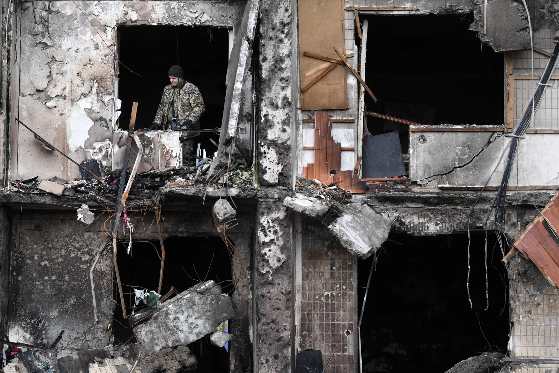 Un militar ucraniano en la ventana de un edificio residencial dañado en la calle Koshytsa, un suburbio de la capital ucraniana, Kiev, donde supuestamente cayó un proyectil