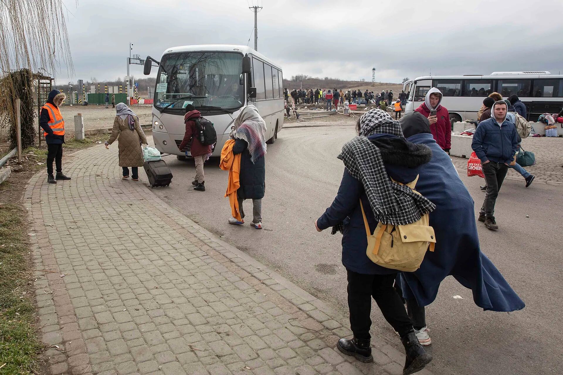 Refugiados cruzan la frontera en autobús