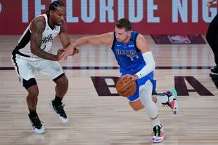 Luka Doncic (77) de los Dallas Mavericks contra Kawhi Leonard (2) de Los Angeles Clippers durante la primera mitad de un juego de playoffs de la primera ronda de baloncesto de la NBA el martes 25 de agosto de 2020 en Lake Buena Vista, Florida.