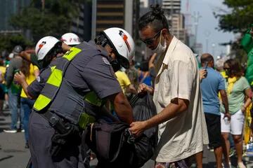 La policía registra a un manifestante antigubernamental durante una manifestación en apoyo del presidente brasileño Jair Bolsonaro en San Pablo, Brasil