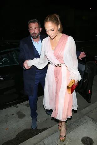 Jennifer Lopez y Ben Affleck llegaron de la mano a su romántica velada en el restaurante italiano Giorgio Baldi en Santa Mónica. Mientras ella lució un vestido de gasa en blanco y rosa que combinó con sandalias y un clutch en dorado, el actor optó por un traje azul oscuro sin corbata. 