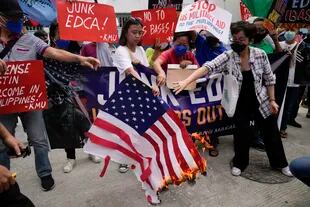 Manifestantes filipinos queman una bandera de Estados Unidos en protesta por la visita del secretario de Defensa de EE.UU., Lloyd Austin, fuera del Camp Aguinaldo, en Manila. (AP/Aaron Favila)