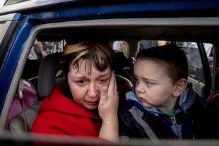 Natalia Pototska, de 43 años, llora ante la mirada de su nieto Matviy en un auto en el centro para personas despkazadas de Zaporizhzhia