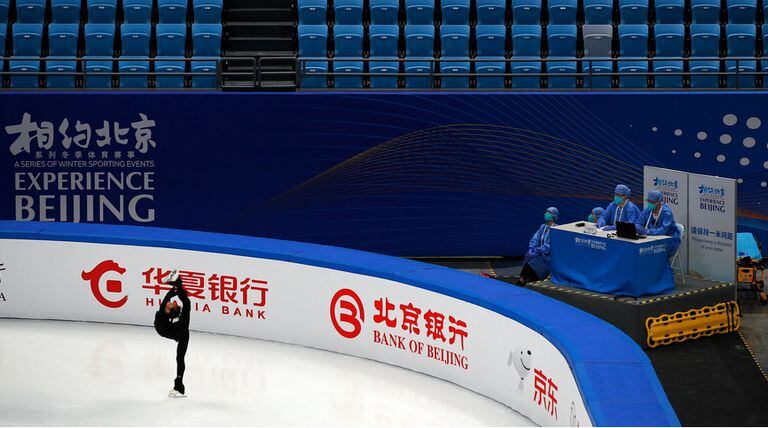 En abril, trabajadores médicos observaron a una patinadora artística durante una prueba de funcionamiento de una sede de los Juegos Olímpicos de Invierno en Pekín. En estos Juegos, la burbuja sanitaria será rigurosa