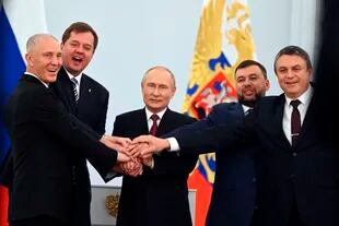 El presidente de Rusia Vladimir Putin y los líderes separatistas posan para una foto durante la ceremonia de firma de los tratados de adhesión de cuatro regiones de Ucrania a Rusia, en el Kremlin en Moscú, el viernes 30 de septiembre de 2022.