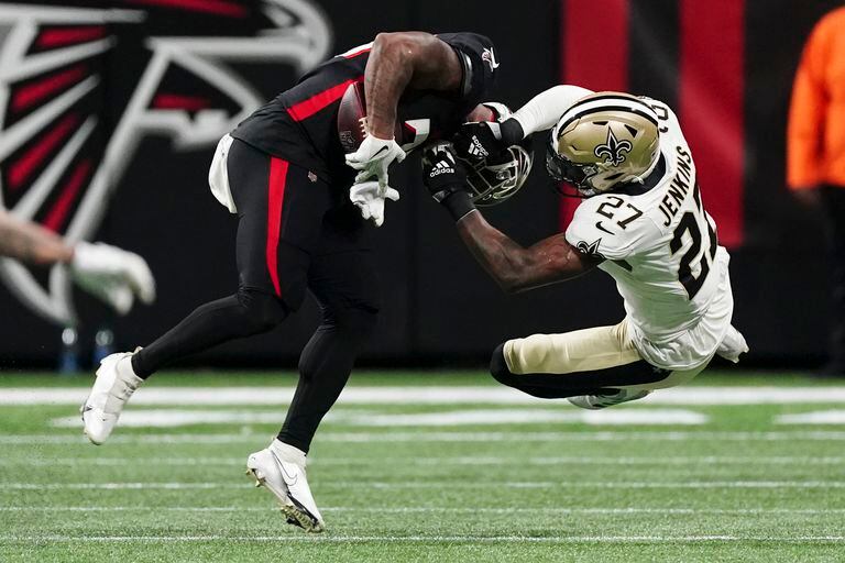 El running back de los Falcons de Atlanta, Mike Davis, es golpeado por el safety de los Saints de Nueva Orleans, Malcolm Jenkins, en la primera mitad del juego del domingo 9 de enero de 2022, en Atlanta. Davis perdió el balón en la jugada. (AP Foto/John Bazemore)