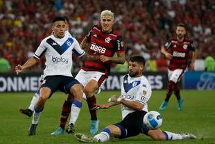 Pedro remata entre Francisco Ortega y Matías De los Santos; el delantero de Flamengo es el goleador de la Copa Libertadores, con 12 festejos en la misma cantidad de partidos