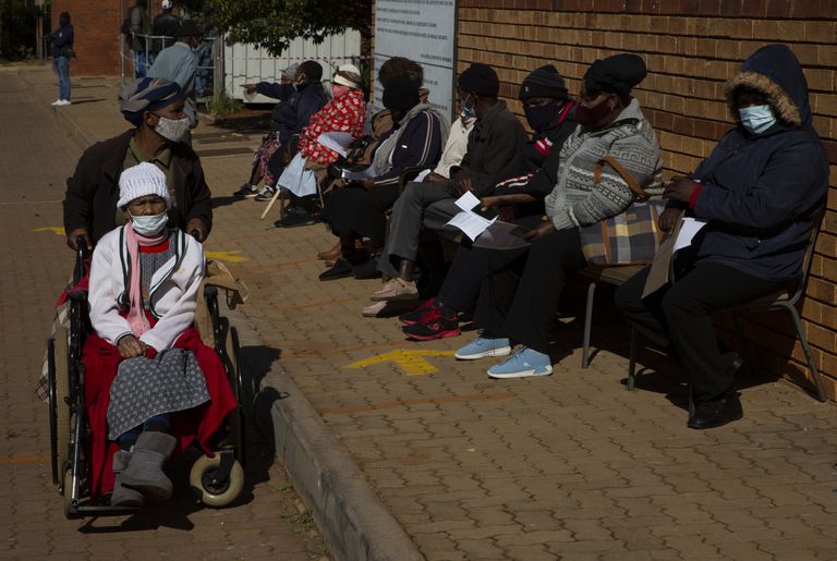 Una mujer abandona el lugar en que otras esperan recibir la vacuna de Pfizer contra el Covid-19 en una clínica en Orange Farm, cerca de Johannesburgo, en Sudáfrica